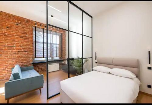 1 dormitorio con cama blanca y pared de ladrillo en Palace of Culture Loft Apartment en Varsovia