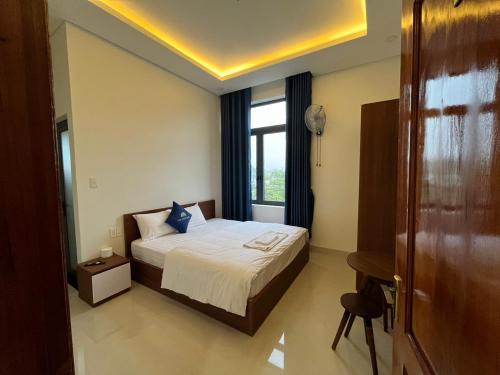 a hotel room with a bed and a window at Nhà Nghỉ Ánh Dương in Quang Ngai