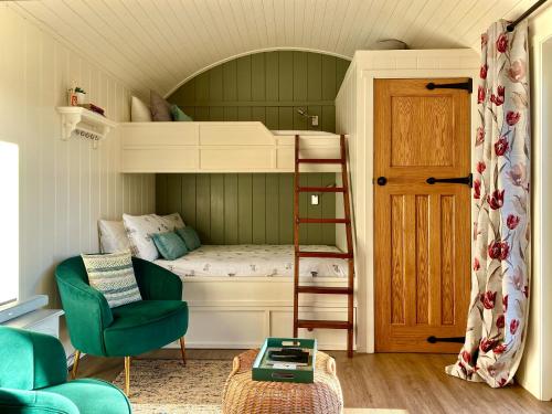 a bedroom with a bunk bed with a ladder and a chair at Bailey's Hideaway in Portadown