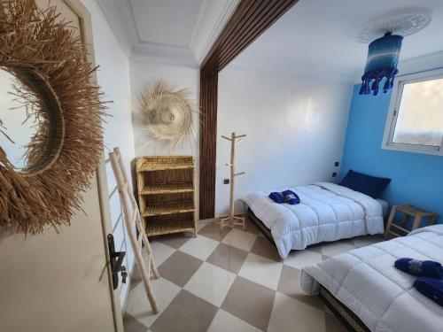 a bedroom with two beds and a cross on the wall at Green Surf House in Agadir