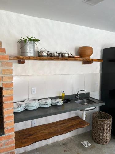 a kitchen with a counter with dishes and a sink at Casa di Maria flats in Icaraí