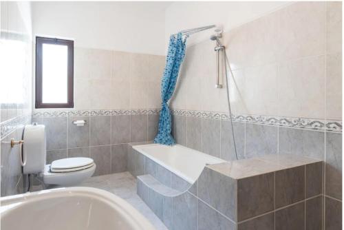 a bathroom with a tub and a toilet and a sink at Villa Alegria in Loulé