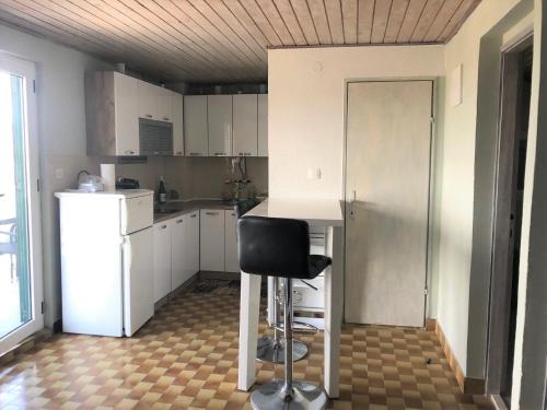 a kitchen with a desk and a chair in it at Villa Luger 2 Dachgeschoss in Rogoznica