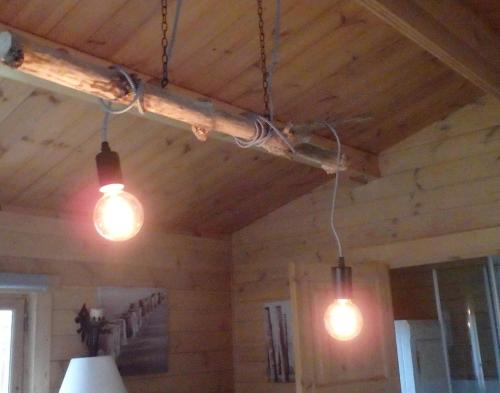 three lights hanging from a wooden ceiling in a room at Huis H8 in Epe
