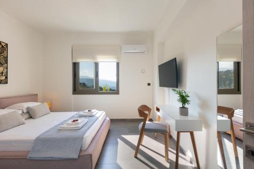 een slaapkamer met een bed, een tafel en een bank bij Villa Elia in Maroulás