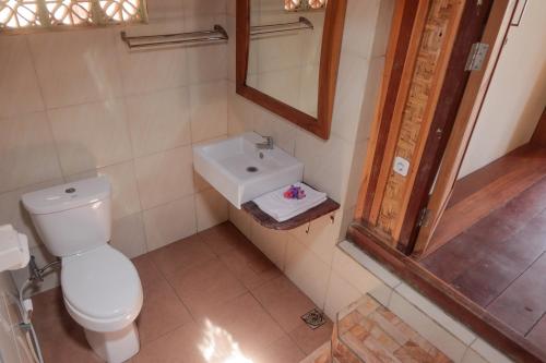 La salle de bains est pourvue de toilettes et d'un lavabo. dans l'établissement Yut's Inn Flower Paradise Gili Gede, à Gili Gede