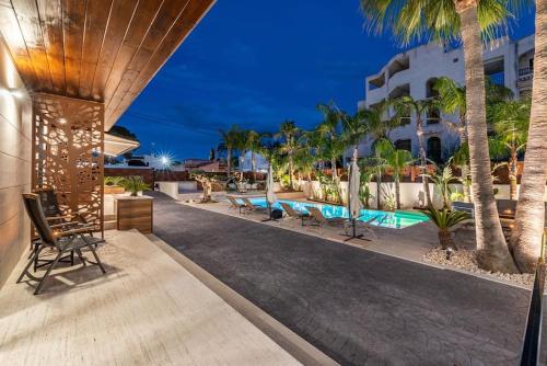 a resort with a swimming pool and palm trees at Luxury Casa con piscina, wifi, 150m dal mare in Miami Platja