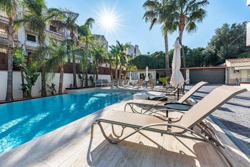 a swimming pool with chaise lounge chairs next to a building at Luxury Casa con piscina, wifi, 150m dal mare in Miami Platja