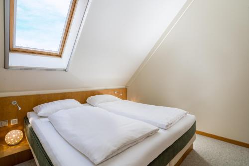 a bed in a room with a window at Romantischer Seegasthof & Hotel Altes Zollhaus in Feldberg