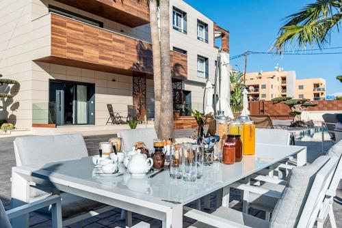 a white table with glasses and bottles on a patio at Luxury Casa con piscina, wifi, 150m dal mare in Miami Platja