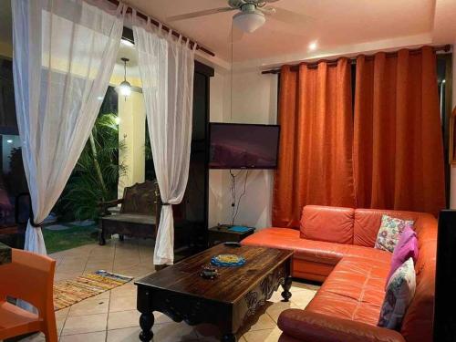 een woonkamer met een bank en een tafel bij Family condo in Jaco, jacuzzis, pools and terrace in Jacó