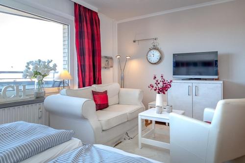 uma sala de estar branca com um sofá e uma televisão em Step8_18 em Westerland