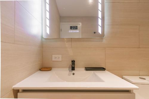 a bathroom with a white sink and a mirror at Caya di Bista Bunita 6 in Palm-Eagle Beach