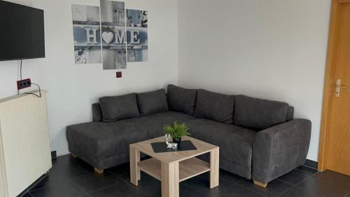 a living room with a gray couch and a table at Ferienwohnung Staufenberg 2 in Staufenberg