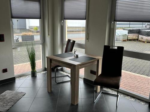 a table and two chairs in a room with windows at Ferienwohnung Staufenberg 2 in Staufenberg
