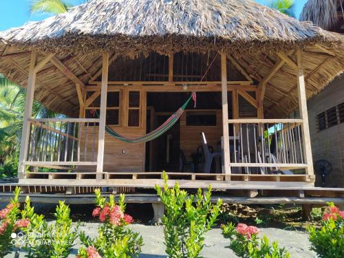 a hut with a hammock in front of it at Bungalow Palmar del Viento by AMAUNA in Moñitos