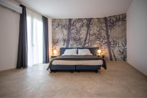 a bedroom with a bed and a wall with trees at Residence Molino - Holiday Apartments in Manerba del Garda