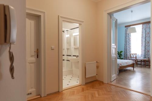 a hallway with a door open to a room with a bedroom at Sibelius Apartments in Prague