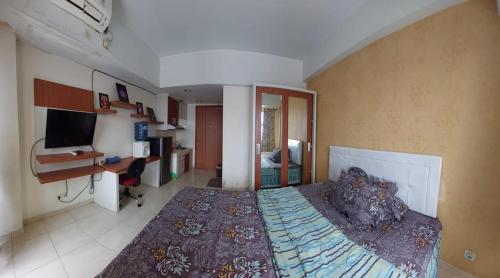 1 dormitorio con 1 cama grande y escritorio en Apartemen Margonda Residence 3, en Kemirimuka Dua