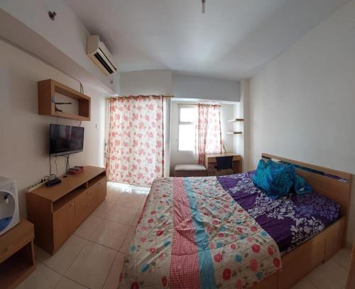 1 dormitorio con 1 cama y TV en Apartemen Margonda Residence 3, en Kemirimuka Dua