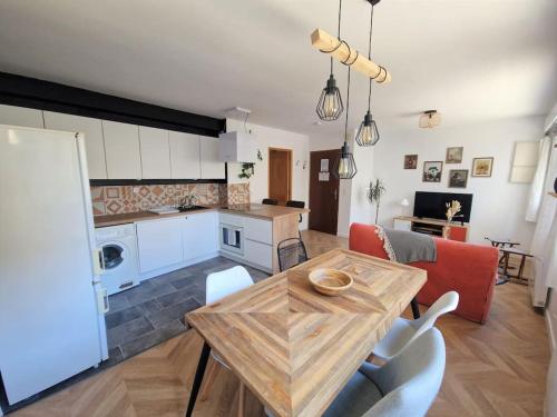 een keuken en een woonkamer met een tafel en stoelen bij T2 refait à neuf avec parking à 1000m du lac in Annecy