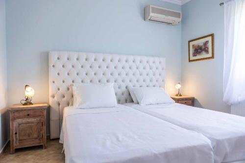 Villa Tramonto Minies في Minia: غرفة نوم بسرير ابيض كبير وموقف ليلتين