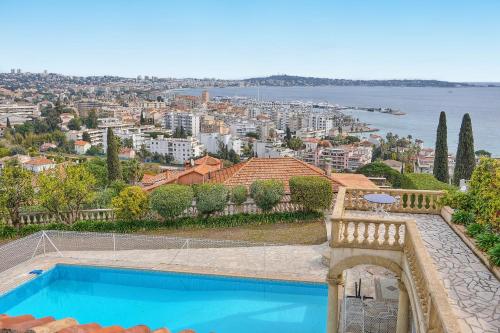 une maison avec une piscine et une vue sur la ville dans l'établissement IMMOGROOM- Top of villa 200m2 - Garden - Pool - Sea view - Parking - Wifi, à Vallauris