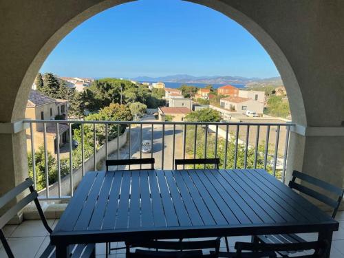 une table bleue sur un balcon avec vue sur la rue dans l'établissement Appartement T3 Les eucalyptus, à LʼÎle-Rousse