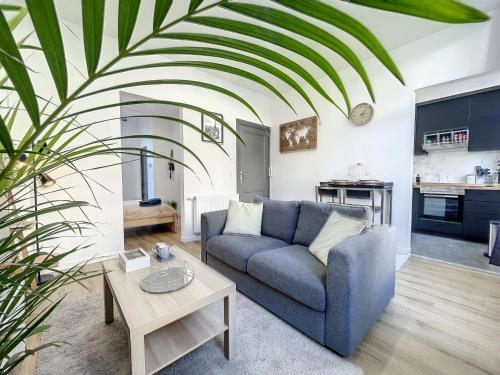 un soggiorno con divano blu e tavolo di Cosy Apartment Brussels - Palais Royal a Bruxelles