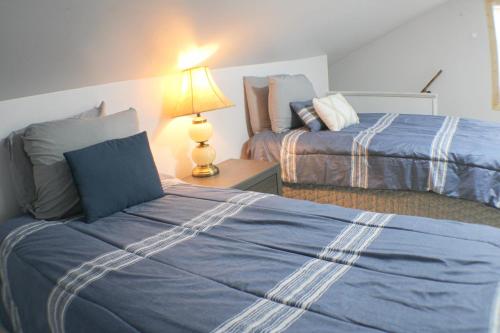 a bedroom with two beds and a lamp on a table at 3 BR Southside Pad - Sleeps 8 - Amazing Location in Pittsburgh