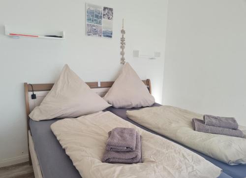 two beds in a room with towels on them at Die kleine Freiheit Grömitz Center - Unmittelbare Strandlage mit allem Komfort in Grömitz