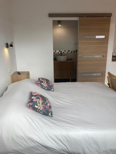 a white bed with two pillows on top of it at La marine D'opale in Ambleteuse