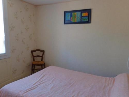 - une chambre avec un lit, une chaise et une photo dans l'établissement Appartement F2 cosy, 4 couchages, centre-ville, proche cures, balcon, animaux acceptés - FR-1-703-102, à Amélie-les-Bains-Palalda