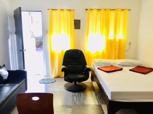 ein Zimmer mit 2 Betten und einem Stuhl darin in der Unterkunft Harvey's Place in Cagayan de Oro