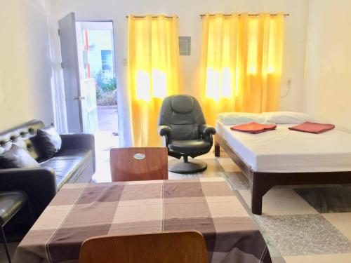 ein Wohnzimmer mit 2 Betten und einem Stuhl in der Unterkunft Harvey's Place in Cagayan de Oro