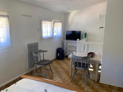 - une chambre avec un bureau, une table et des chaises dans l'établissement Duplex confortable avec grande terrasse, climatisation et proche des thermes - FR-1-703-114, à Amélie-les-Bains-Palalda