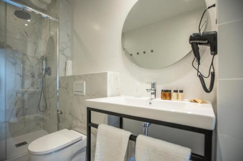 a bathroom with a sink and a mirror and a toilet at Fontanella By BCN URBAN Rooms in Barcelona