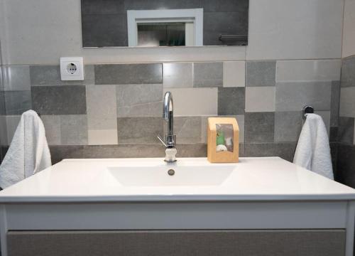 a bathroom sink with a faucet and a mirror at 4 Mares Apartamentos A in Loredo