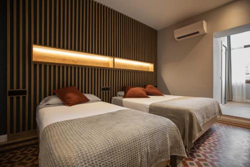 two beds in a room with black stripes at Fontanella By BCN URBAN Rooms in Barcelona