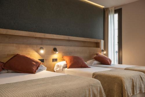 a hotel room with two beds with orange pillows at Fontanella By BCN URBAN Rooms in Barcelona