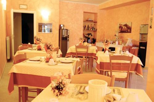 un restaurante con mesas y sillas con manteles blancos en Green Quiet Affittacamere, en Pignone