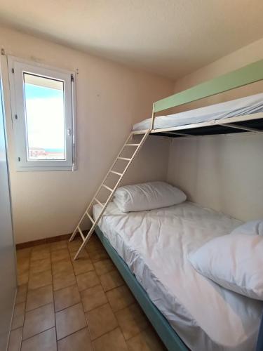 une chambre avec deux lits superposés et une échelle dans l'établissement T3 Cabine avec piscine collective à 900 m de la Plage 5LHSP138, à Saint Pierre La Mer