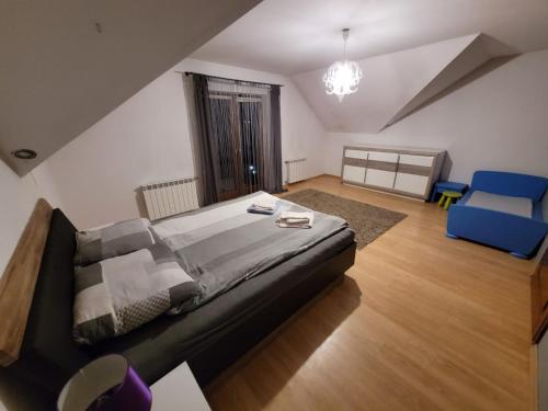 ein Schlafzimmer mit einem großen Bett und einem blauen Stuhl in der Unterkunft Cztery Pory Roku in Rabka-Zdrój