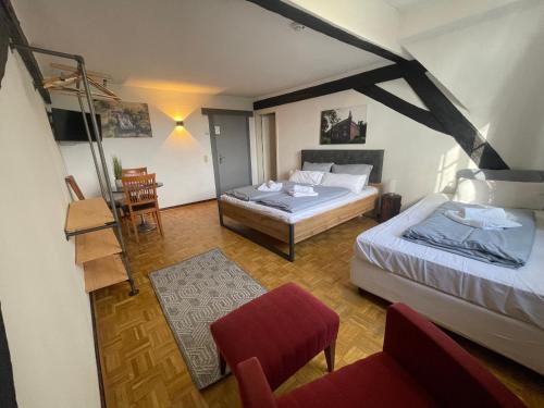 Großes Zimmer mit 2 Betten und einem Stuhl in der Unterkunft Hotel Schloss Walbeck in Geldern