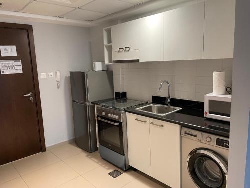 a small kitchen with a sink and a refrigerator at BEAUTIFUL STUDIO APARTMENT IN AL MARJAN ISLAND in Ras al Khaimah