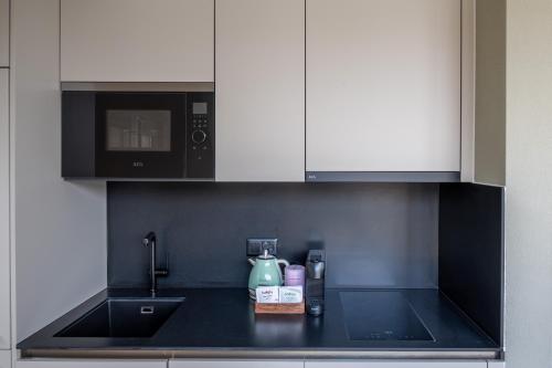 a kitchen with a sink and a microwave at Numa Zurich Craft in Zürich