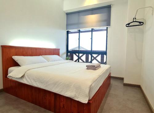 een bed in een kamer met een groot raam bij Mahkota Pool View Apartment near A’Famosa & Jonker in Melaka
