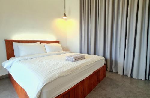 - une chambre avec un grand lit et des draps blancs dans l'établissement Mahkota Pool View Apartment near A’Famosa & Jonker, à Malacca