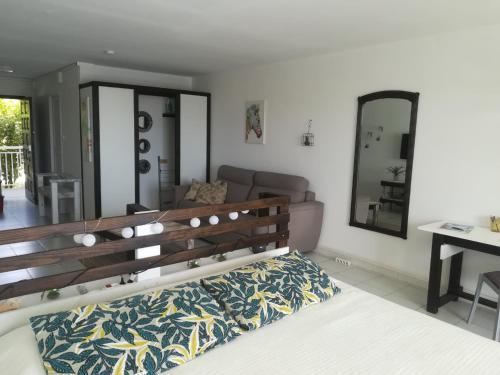 a bedroom with a bed and a couch and a mirror at Happy Residence - Orient Beach 09 in Cul de Sac