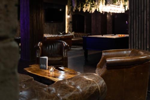 a bar with leather chairs and a table and a pool table at Derwent Manor Boutique Hotel in Consett